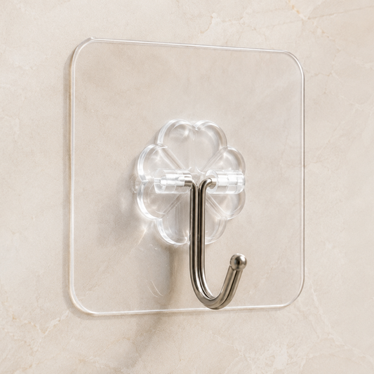 A clear acrylic wall hook with a metallic silver J-shaped hook, mounted on a beige marble-patterned wall.