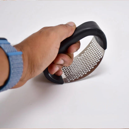 Hand holding a handheld metal grater on a white background